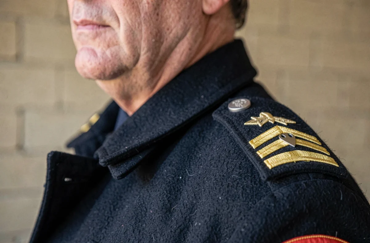 Gros plan sur les insignes de grade et chevrons brodés sur l'épaulette d'un uniforme de pompier